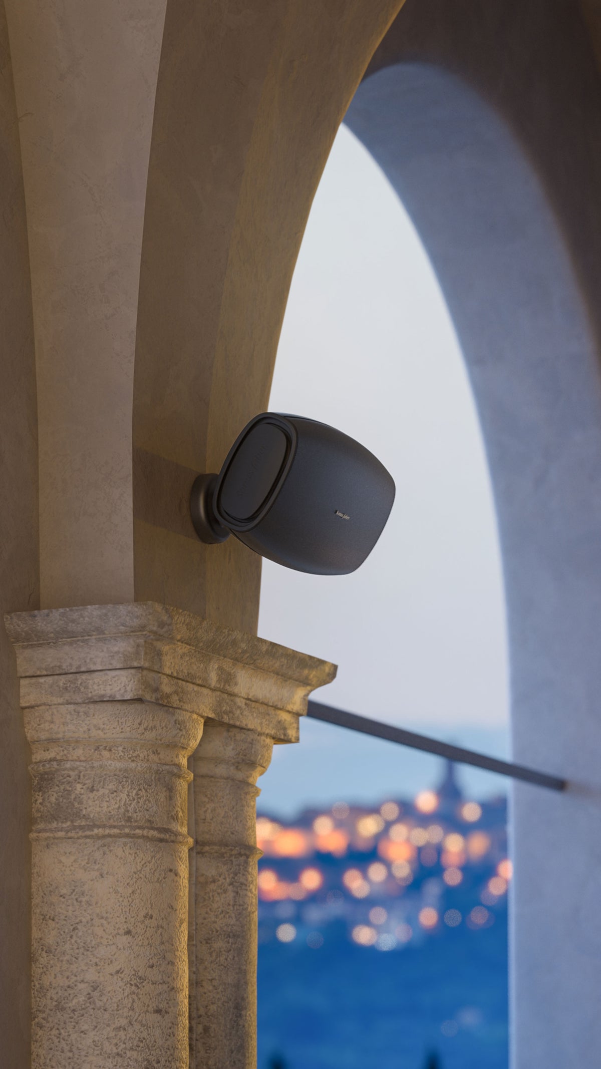 A Sonus faber Aster outdoor speaker custom-installed on an exquisite cement column in a beautiful outdoor environment