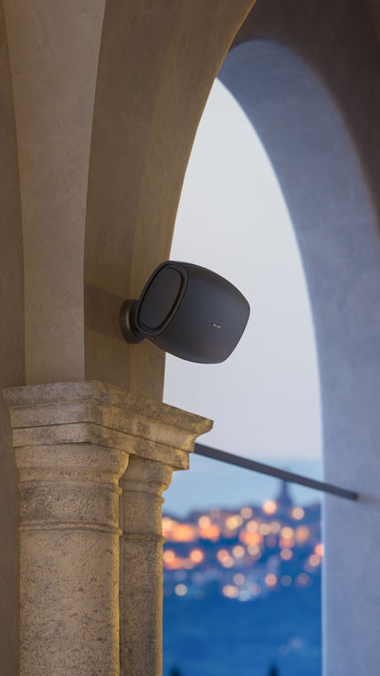 A Sonus faber Aster outdoor speaker custom-installed on an exquisite cement column in a beautiful outdoor environment
