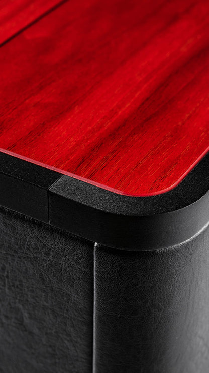 Close-up of the Gravis V subwoofer, highlighting intricate details with a stunning red wood color and luxurious black leather finishes.