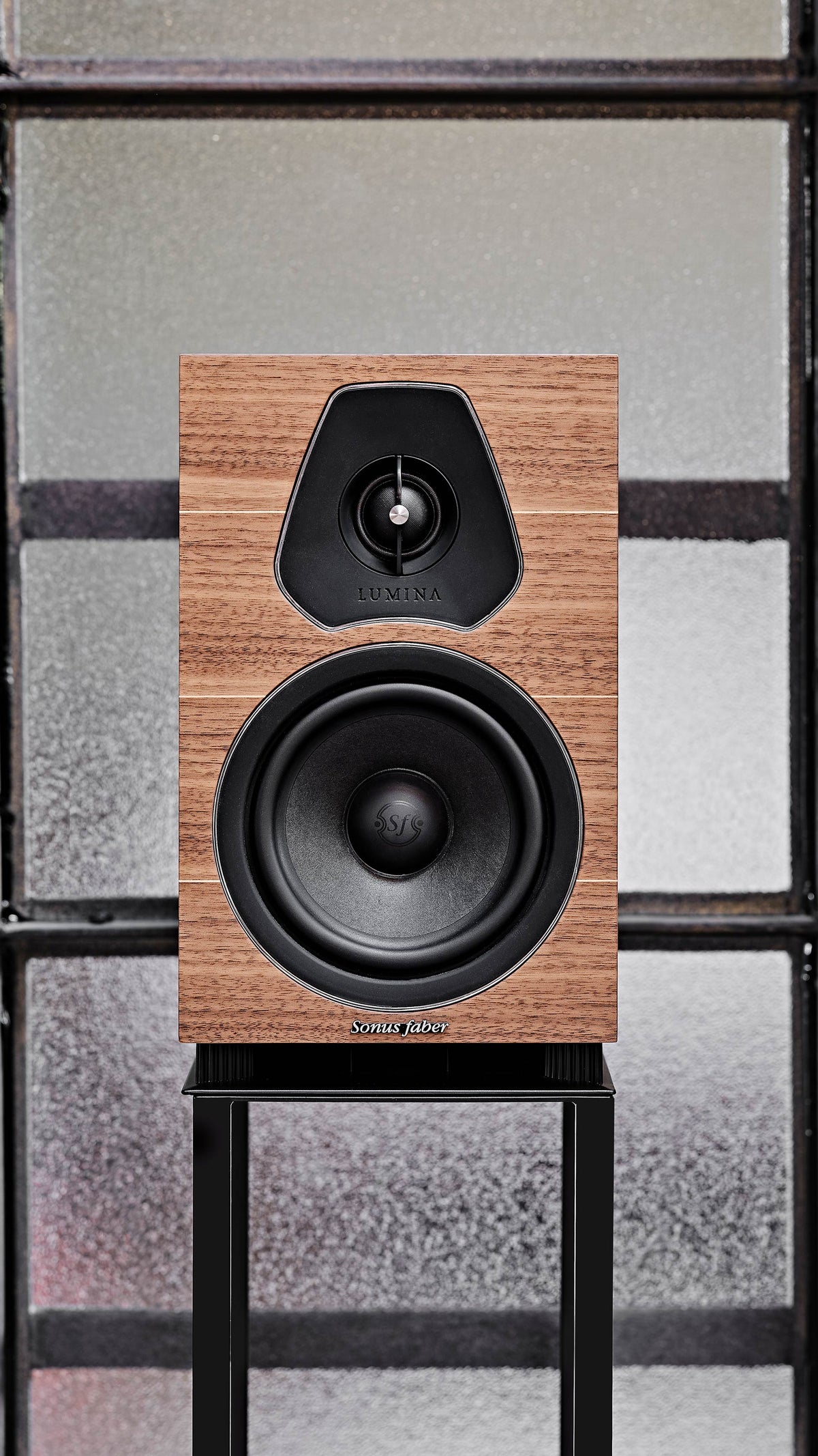 Sonus faber Lumina II Bookshelf speaker elegantly showcased on a stand, featuring walnut wood and emphasizing natural materials.
