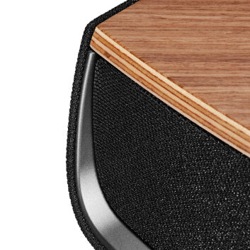 Sonus faber Omnia wireless bookshelf speaker in Walnut, Black fabric, and Aluminum/Titanium finishes, highlighting its sleek design.